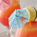 A close-up of a drink with a Choice paper umbrella and a lemon slice.