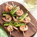 A plate of shrimp and asparagus skewers on wooden EcoChoice skewers.