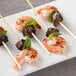 EcoChoice compostable bamboo skewers with shrimp, basil, and mint on a plate.