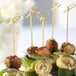 A plate of food on skewers with a Bamboo by EcoChoice bamboo knot skewer.