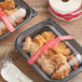 TamperSafe red paper label wrapped around plastic containers of chicken.