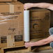 A man holding a roll of 20" x 1000' Pallet Wrap Film.