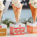 A row of waffle ice cream cones on a table.