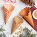 Three Konery peppermint waffle cones with candy canes in them.