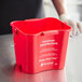 A red San Jamar sanitizing bucket with white text and a handle.