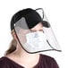 A woman wearing a Choice black 6-panel cap with a detachable PVC face shield and a mask.