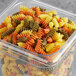A plastic container of tri-color spiral pasta.