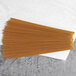 A pile of Barilla whole grain spaghetti on a white surface.