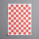A red and white checkered paper with the product name "Choice 9" x 12" Red Check Basket Liner / Deli Sandwich Wrap Paper" on a gray surface.
