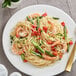 A plate of Barilla Capellini pasta with shrimp and asparagus.