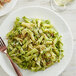 A plate of Barilla Campanelle pasta with pesto sauce and a fork.