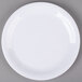 A white Carlisle melamine salad plate with a white rim on a gray surface.