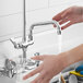 A hand washing under a Regency add-on faucet with 8" swing spout.