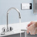 A person using a 6" long gooseneck spout to wash their hands.