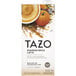 A white carton of Tazo Pumpkin Spice Latte concentrate with a cup of Pumpkin Spice Latte on it.