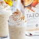 A close-up of a Tazo Pumpkin Spice Latte with whipped cream and cinnamon.