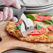 A person using a Choice pizza cutter with a black handle to cut a pizza.