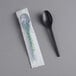 A wrapped EcoChoice black compostable plastic spoon.