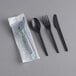 A black plastic EcoChoice spoon, fork, and knife set in plastic wrap.