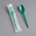 A green EcoChoice CPLA spoon in plastic wrapping.