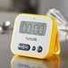 A yellow Taylor digital kitchen timer on a counter.