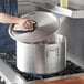A man using a Choice aluminum sauce pot on a stove.