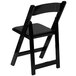 A black Flash Furniture folding chair with a black cushion and wooden seat.