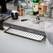 A stainless steel beer drip tray on a bar counter.
