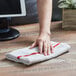 A person using a red and white striped Choice bar towel to clean a counter.