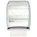 A stainless steel look San Jamar Tear-N-Dry paper towel dispenser with a roll of paper.