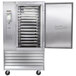 A Traulsen stainless steel cabinet with a right hinged door open with trays inside.