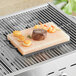 A piece of steak and shrimp being grilled on a Himalayan salt slab.