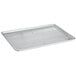 A Baker's Mark stainless steel footed wire cooling rack on a table over a full size baking sheet.