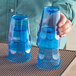 A person holding two blue Choice plastic tumblers.
