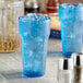 Two blue Choice plastic tumblers with ice on a counter.
