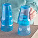 A person holding a pair of Choice blue plastic tumblers.