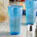 Two blue Choice plastic tumblers filled with ice water.