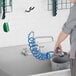 A person using a Waterloo pet grooming faucet hose to wash a sink.