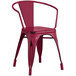 A red metal Lancaster Table & Seating outdoor arm chair.