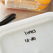 A white Vigor polypropylene food storage container lid with black writing on it.