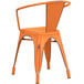 A Lancaster Table & Seating distressed orange metal outdoor arm chair with a backrest.