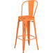An orange metal Lancaster Table & Seating outdoor cafe barstool with a backrest.