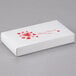 A white rectangular candy box with red hearts on it.