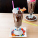 Two Anchor Hocking soda glasses filled with chocolate milkshakes and candy and sprinkles on top.
