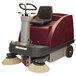 A red and white Minuteman Kleen Sweep floor sweeper with a seat.
