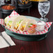 A red and white checkered table with a plate of tacos and a Jalapeno Deli Server with salsa in it.