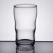 A Libbey clear juice glass with a rim on a table.