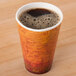 A Dart Fusion Escape foam hot cup filled with coffee on a wooden table.