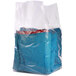 A close-up of a clear Choice gusseted polyethylene bag filled with a blue blanket.