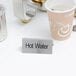 A double sided stainless steel table tent sign that says "Hot Water" with a tea cup and tea pot on it.
